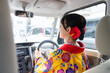 沖縄県那覇市で琉装で車を運転する２０代の若い日本人女性 A young Japanese woman in her 20s driving a car in Ryuso in Naha City, Okinawa Prefecture