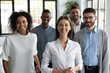 Happy successful coworkers and start-up coach. Group portrait of aspiring young professionals at work, smiling and looking at camera. Friendly multiracial company staff together in modern workspace