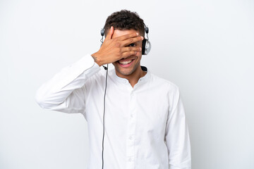 Wall Mural - Telemarketer Brazilian man working with a headset isolated on white background covering eyes by hands and smiling