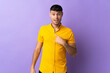 Young Colombian man isolated on purple background with surprise facial expression