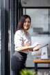 © David - Young asian busy professional business woman executive, female company worker or manager holding digital tablet technology device working standing in modern corporate office.