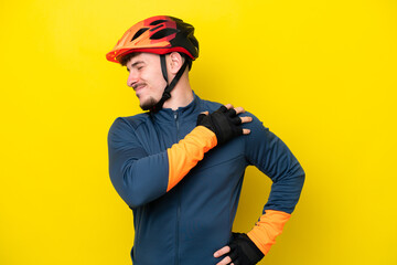 Wall Mural - Young cyclist caucasian man isolated on yellow background suffering from pain in shoulder for having made an effort