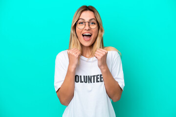 Sticker - Young volunteer Uruguayan woman isolated on blue background celebrating a victory in winner position