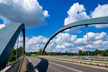Wall Mural - Bridge spans over highway under blue sky