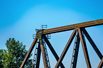 Wall Mural - Old wooden railroad bridge against the blue sky