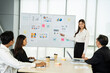 © Bavorndej - Young asian business woman presenting business chart with team in meeting room. Business meeting concept.