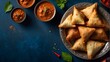 Savor Indian cuisine such as tikka masala, samosas, burgers, and desserts with spices and mint chutney while celebrating Diwali. On a background of dark blue, copy space.