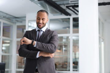 Canvas Print - Happy man looking at his watch in office, space for text. Lawyer, businessman, accountant or manager