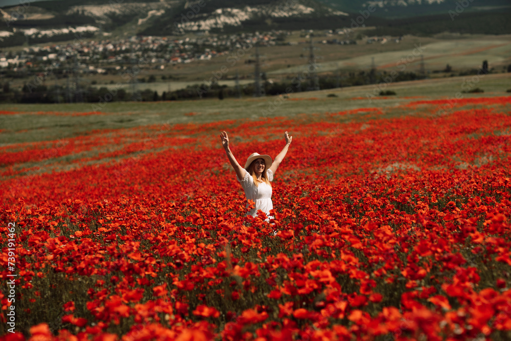 Field poppies woman. Happy woman in a white dress and hat stand through ...