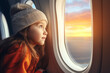 Little girl looking through a window in a plane