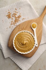 Wall Mural - Tasty mustard sauce and dry seeds on light textured table, flat lay