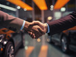 Buyer shakes hands with sales agent after successfully buying car at dealership