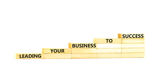 Wall Mural - Leading your business to success symbol. Concept words Leading your business to success on wooden blocks. Beautiful white table white background. Leading your business to success concept. Copy space.