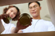 © DragonImages - Volunteers putting canned food in box, view from inside the box