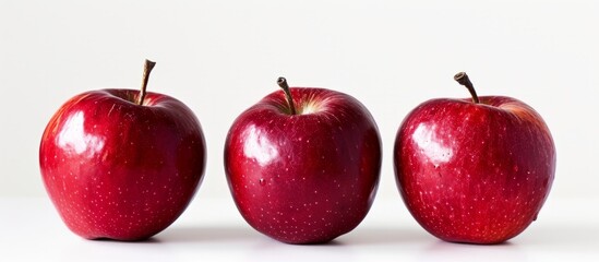 Canvas Print - Three vibrant red apples on a clean white background for healthy eating concept