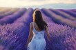 a woman in a white dress is walking through a lavender field