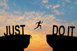 © Philip - Man jumping on I can do it or I can't do it text over cliff on sunset background, Business concept idea.