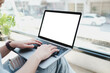 © Thaspol - A white blank screen for hand typing text,using laptop contact business searching information in workplace on desk at cafe.