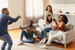 © Prostock-studio - International students gathering in living room for game of charades