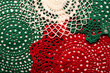 © Alena Vilgelm - Handmade crochet doily in red, green, and white colors, symbolizing cozy Christmas decor and craft traditions.