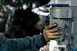 © Guys Who Shoot - A car mechanic stands at a service station and presses button on a pole to raise the car