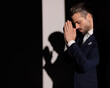 © Viorel Sima - side view of elegant fashion man in suit holding hands together and praying