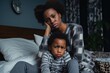 Worried African American Mother with Child. A mother sits in contemplation beside her young son, reflecting a sense of concern and care.