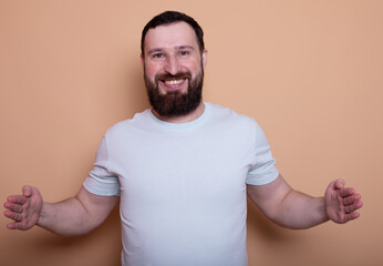 Wall Mural -  man with a beard is smiling and holding his hands up in the air. He is wearing a white shirt and he is posing for a picture