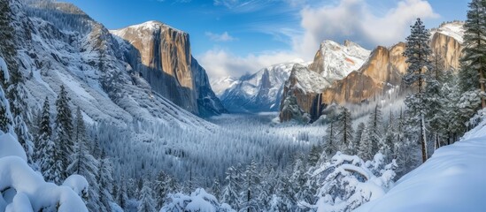 Wall Mural - A picturesque natural landscape featuring a snowy valley nestled among snowcovered mountains and trees under a cloudy sky. A serene world of mountainous landforms perfect for travel and exploration