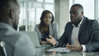© Studio Nova - group of business professionals engaged in a serious discussion around a glass table in a modern office setting.