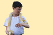 Teenage boy with albino python on neck on light yellow background. Copy space.