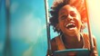Happy African American kid boy laughing on a swing on a warm sunny day on a playground. Concept of carefree play, happy childhood, summer fun, and outdoor activities. Copy space