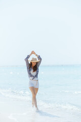 Wall Mural - Full length portrait of happy woman on ocean coast walking