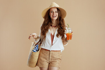 Wall Mural - smiling woman in blouse and shorts against beige