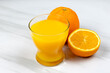 verre de jus d'orange et oranges fraiches sur une table	
