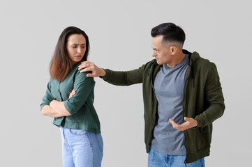 Wall Mural - Offended young couple with her husband on light background