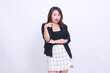 © Ajab - beautiful Asian Indonesian woman in her 20s in the office shocked with her arms crossed and pointing to the left isolated on a white background