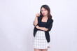 © Ajab - Beautiful Asian Indonesian girl in her 20s in the office frowning with her arms crossed and pointing at the camera isolated on a white background
