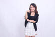 © Ajab - Beautiful Asian Indonesian girl in her 20s in the office cheerful smile arms crossed and pointing to the left isolated on white background