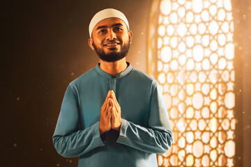 Wall Mural - Portrait of handsome young asian muslim man with beard praise, thankful and smiling in the mosque window arch