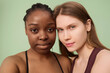 © AnnaStills - Close-up studio portrait of young Black and Caucasian women with no makeup wearing sports bras looking at camera