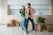 © DimaBerlin - Dancing of joy and happiness, overjoy married couple have fun in spacious apartment with packed cardboard boxes. Pleased homeowners celebrating moving into own new purchased flat. Dream family home.