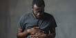African-American man holds stomach painful suffering from stomachache causes of gastric ulcer, appendicitis or gastrointestinal system desease. Healthcare and health insurance concept