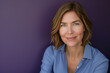 © Rafa Fernandez - Pretty woman in blue blouse with short blonde hair looking at camera against a purple background