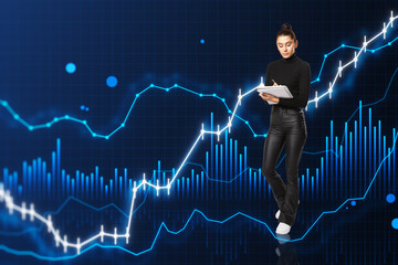 Canvas Print - Attractive young woman doing paperwork while standing on blue background with glowing and growing business chart. Financial growth, trade and stock concept.