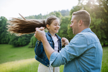 Wall Mural - Dad with daughter, playing at meadow, running, having fun. Concept of fathers's Day and fatherly love.