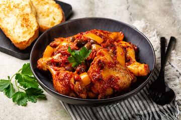 Poster - Chicken cacciatore, hunter-style italian chicken with tomatoes,  Taggiasca olives and yellow bell peppers. Bread toast.