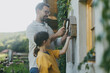 © Halfpoint - Father with daughter making bug hotel, or insect house outdoors in the garden. Girl learning about insects, garden ecosystem and biodiversity.