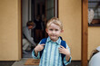 © Halfpoint - Schoolboy with backpack on back standing in frotn of house. Preparation for school day, morning.