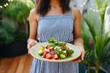 © Hanna Haradzetska - A trendy girl dinner presenting a refreshing watermelon and feta cheese salad, on a beautiful plate in a lush garden patio setting
